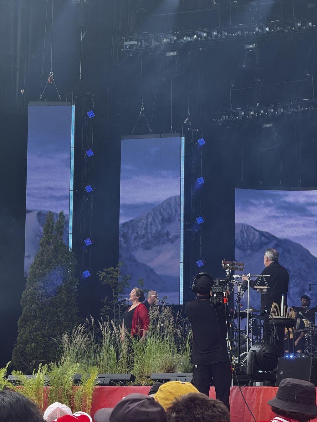 Deantha Edmunds-Ramsay performing "Anānak Silatsuaimāk"

The stage background is blue with rocky cliffs
- - -
Deantha Edmunds-Ramsay interprète « Anānak Silatsuaimāk »

L'arrière-plan de la scène est bleu avec des parois rocheuses