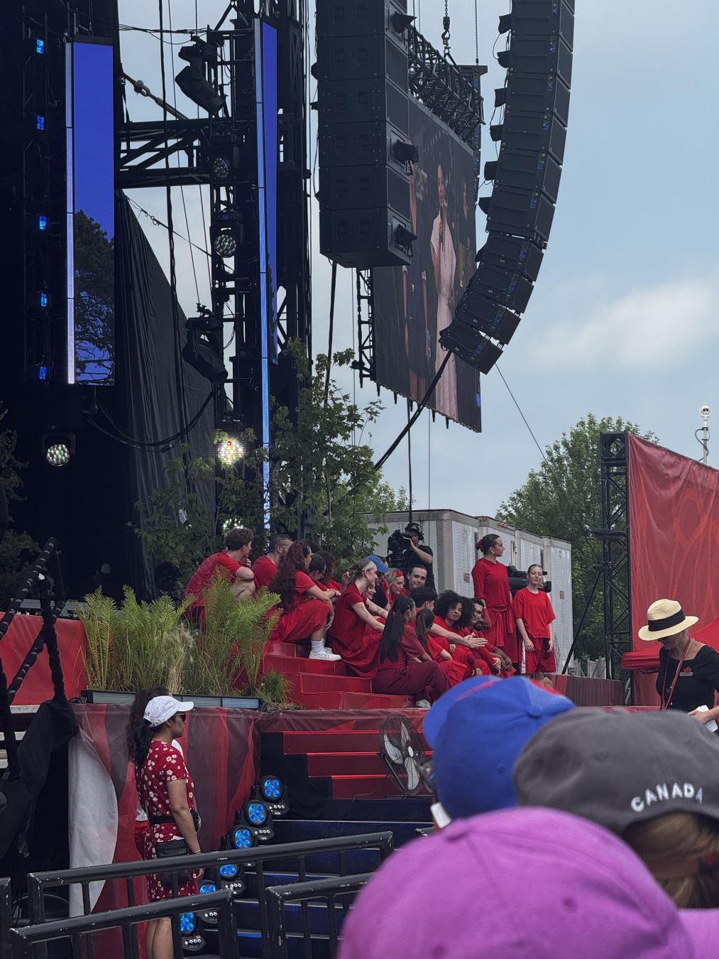 17 dancers on the stage during Loud's performance. They're all wearing red. 

Two of the dancers are standing.
- - -
17 danseurs.euses sur scène pendant la performance de Loud. Iels portent tous du rouge.

Deux des danseuses sont debout.