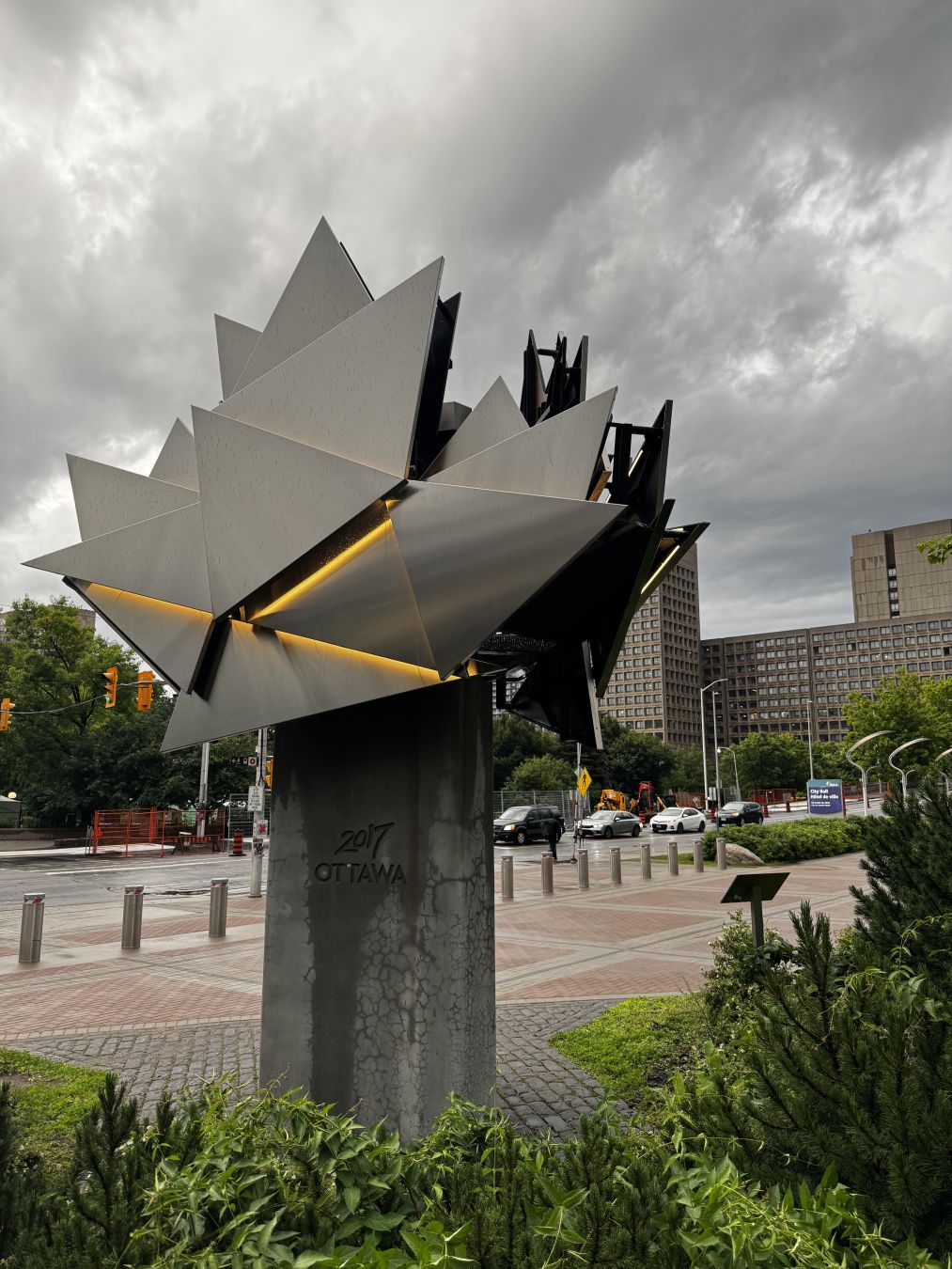 A stylized Maple Leaf made out of some metal. It has a warm yellow light on it.

On its stand, it's written "2017 Ottawa"
- - -
Une feuille d'érable stylisée faite en métal. Il y une couleur jaune douce qui y brille.

Sur son pied, on peut lire "2017 Ottawa"